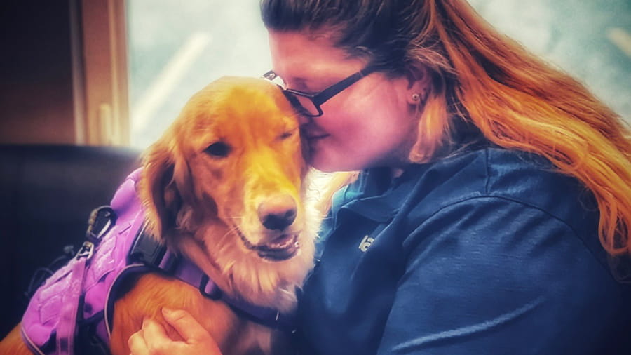 VCA Far Country associate snuggling a dog