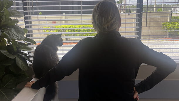 Woman and cat looking out a window