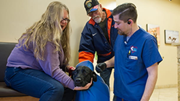 Vet tech with dog and clients